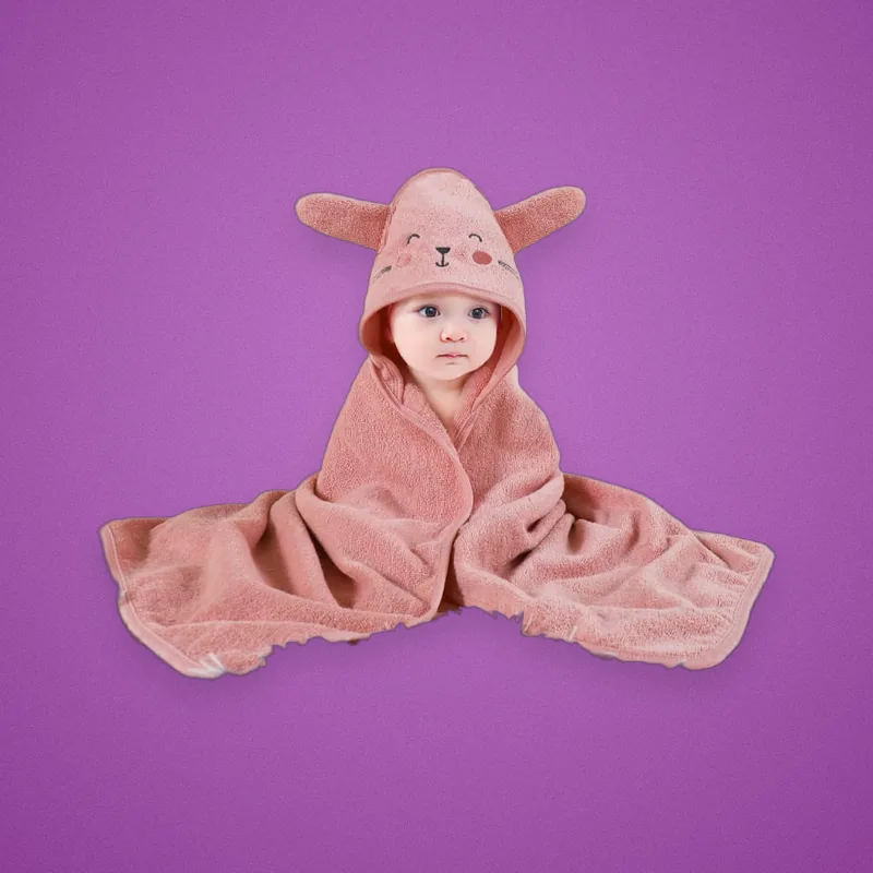 Baby wrapped in a pink hooded towel with bunny ears