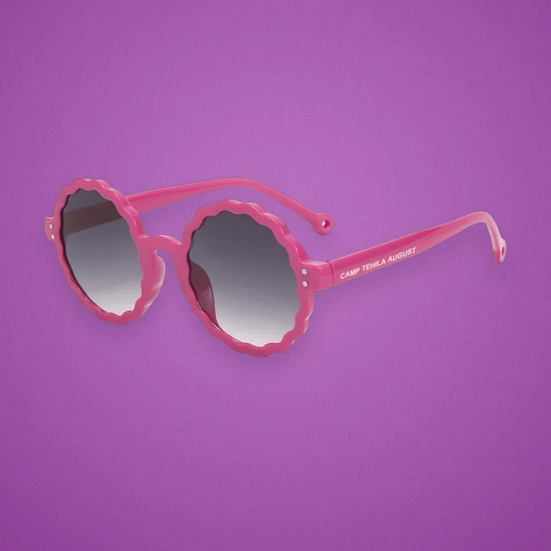 Pink scalloped kids' sunglasses with a camp name printed on the arm